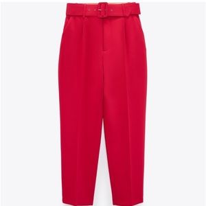 High waisted red pants , with large belt. Trousers with a lined.